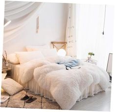 a white bed with fluffy blankets and pillows