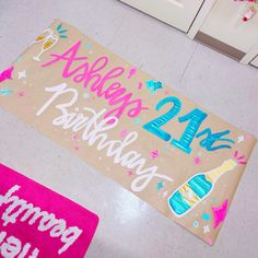 a birthday sign on the floor next to a pink rug