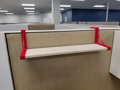 an empty office cubicle with red handles