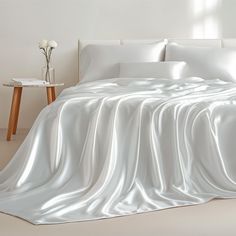 a bed covered in white sheets and pillows