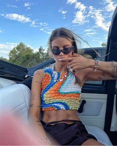 a woman sitting in the back seat of a car with her hand on her mouth