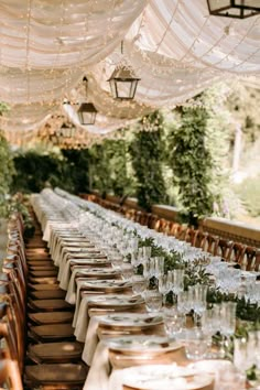 a long table is set with glasses and plates