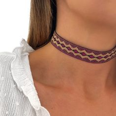 Our Choker AMEROK necklace is embroidered with gold and purple thread, with geometric shapes. It is adjustable with extension, so you can adjust it to the extent you like, leaving it stuck to the neck or a little looser! It is perfect to wear on a day-to-day basis or on special occasions. It is boho style - minimalist, it looks beautiful put! Without a doubt a good option to give or for yourself! All our jewelry can get wet. -MATERIAL: * Gold plated closure 18 kt - LONG FABRIC: * 30 cm with exte Fabric Choker, 70s Jewelry, Choker Handmade, Handmade Chokers, Gold And Purple, Chocker Necklace, Jewelry Personalized, Jewelry Choker, 2024 Fashion