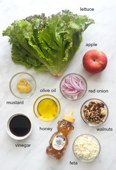 the ingredients for an apple cider salad laid out on a white marble counter top