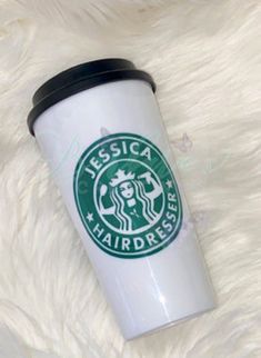 a starbucks cup sitting on top of a white fur covered floor