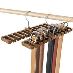 two pairs of shoes hang from a wooden rack with metal clips on it's sides