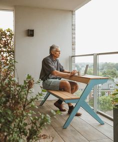 a man sitting at a desk on top of a balcony