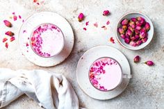 two white bowls filled with pink liquid and rose petals