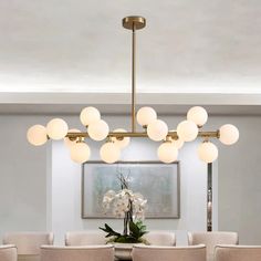 a dining room table with chairs and a chandelier hanging from it's ceiling