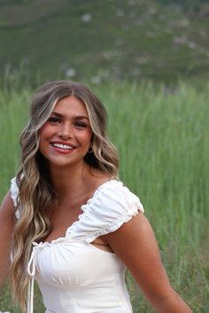 a woman in a white dress posing for the camera