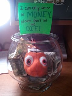 an orange fish in a glass bowl filled with money