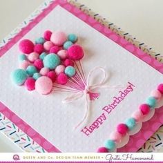 a birthday card with pink, blue and green pom - poms on it