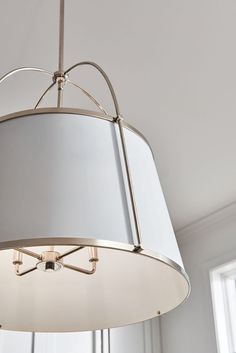 a light fixture hanging from the ceiling in a room with white walls and flooring