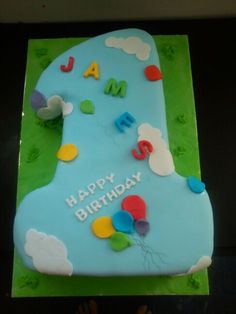 a blue birthday cake with balloons on it