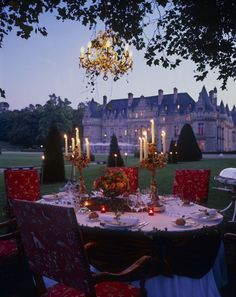 a dining table set up outside in front of a castle