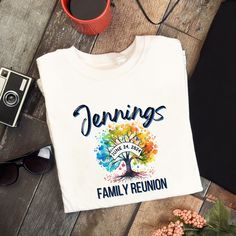 a family reunion t - shirt sitting on top of a table next to a camera