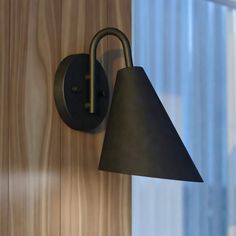 a black lamp mounted on the side of a wooden wall