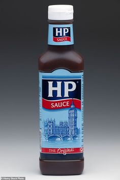 a bottle of hot sauce sitting on top of a white countertop next to a gray background