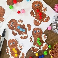 gingerbread cut out with pom - poms and other decorations on a table