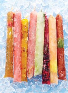 five different colored candy sticks lined up on ice