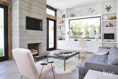 a living room filled with furniture and a flat screen tv mounted on the wall next to a fire place