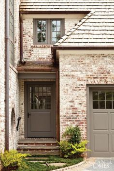 a brick house with two garage doors and windows