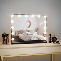 a lighted mirror reflecting a bedroom scene with a bed in the middle and lights on