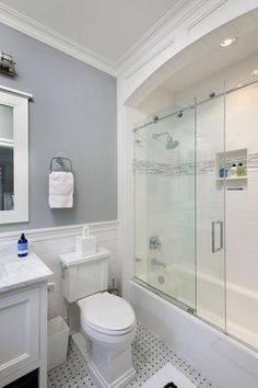 a bathroom with a toilet, sink and shower stall in the middle of the room