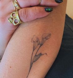 a woman's arm with a flower tattoo on the left side of her arm