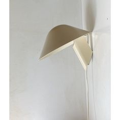 a lamp that is on the wall next to a white wall with a light bulb in it