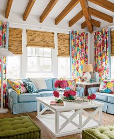 a living room filled with lots of furniture and flowers on the table in front of it