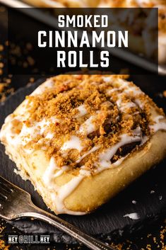 a cinnamon roll with icing and crumbs on it next to a fork