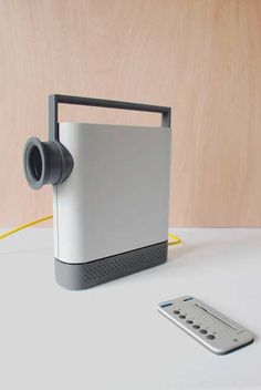 a white and gray object sitting on top of a table next to a remote control