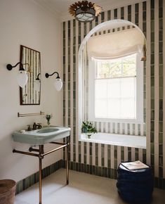 a bathroom with a tub, sink and mirror in it's corner next to a window