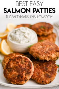 salmon patties on a white plate with lemon wedges