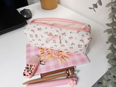 Elevate your stationery game with this Handmade Quilted Floral Pencil Case featuring a charming pink bow. Perfect for students, professionals, or anyone who loves to keep their desk organized, this cute pencil case doubles as a stylish stationery organizer. Crafted with care from soft cotton fabric, the delicate floral pattern and quilted design add a touch of elegance to your daily routine. Whether you're heading back to school or looking for a unique gift, this zipper pouch is versatile enough Pink Zipper Pouch Pencil Case For Study, Pink Pencil Case With Zipper Pouch For Organization, Pink Zipper Pouch Pencil Case For Organization, Pink Stationery With Pen Slots For Organization, Portable Pink Stationery For Organization, Pink Stationery With Pen Holders For Study, Pink Zipper Pouch Stationery For Organization, Pink Portable Stationery For School, Portable Pink Stationery For School