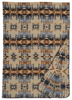 an old navajo blanket with blue, brown and white designs on the front end is folded in