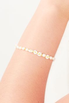 a woman wearing a bracelet with flowers on it