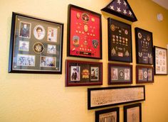 a wall with many framed pictures on it