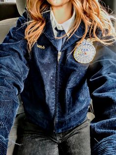 a woman wearing a hat and jacket sitting in the back seat of a car with her hands on her hips