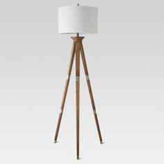 a wooden tripod floor lamp with a white shade