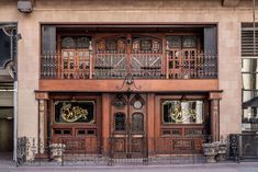 an old building with wooden doors and wrought iron railings