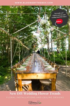 a long table set up for a wedding with flowers and greenery hanging from the ceiling