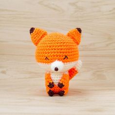 a small crocheted fox is standing on its hind legs