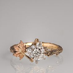 an engagement ring with two leaves on the front and one leaf on the back, set in yellow gold