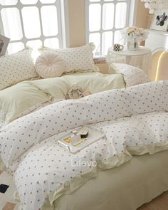 a bed with white sheets and polka dots on it