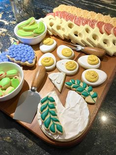 a wooden cutting board topped with lots of different types of cookies and other food items