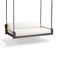 a black swing bed with white pillows on it's sides and two wooden posts