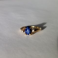 Vintage Mid Century 10 kt Gold Blue Star Sapphire & Diamond Ring Features: Absolutely beautiful ring! Two small diamonds accent the royal blue star sapphire. Beautiful star when then light reflects! Stamped 10 kt on interior of band. Claw settings. Condition: Excellent. Little to no signs of wear. Stones are present, securely mounted, and unblemished. Era: Mid Century, circa 1945 Size: 7.5 US Star Saphire Ring, Sapphire Pinky Ring, Mid Century Ring, Blue Star Ring, Gold And Sapphire Ring, Elegant Star-shaped Sapphire Ring For Anniversary, Safire Rings, Star Engagement Ring, Blue Star Sapphire Ring