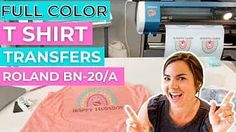 a woman holding up her t - shirt in front of a printer